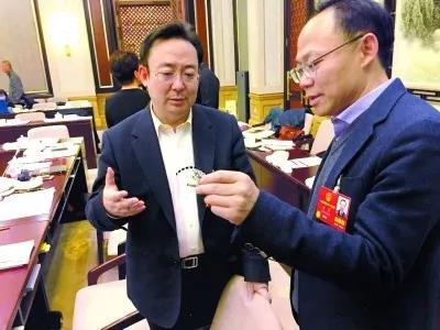 昨天,北京團(tuán)小組會(huì)休息的間隙,程京代表(右)向夏林茂代表介紹基因芯片。張宇攝